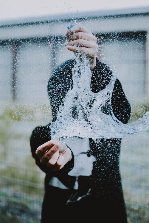 Water in Mid Air Between Standing Person's Hands