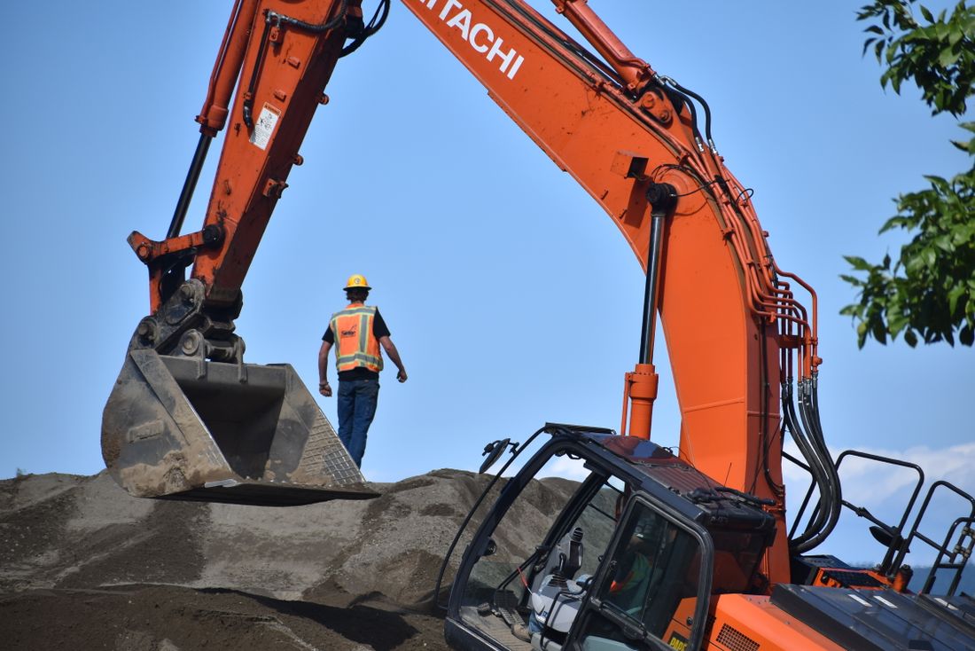Construction worker operating an excavator at a worksite