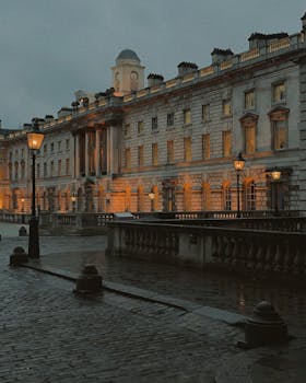 A moody, rainy evening captures the historic architecture of Central London illuminated softly.