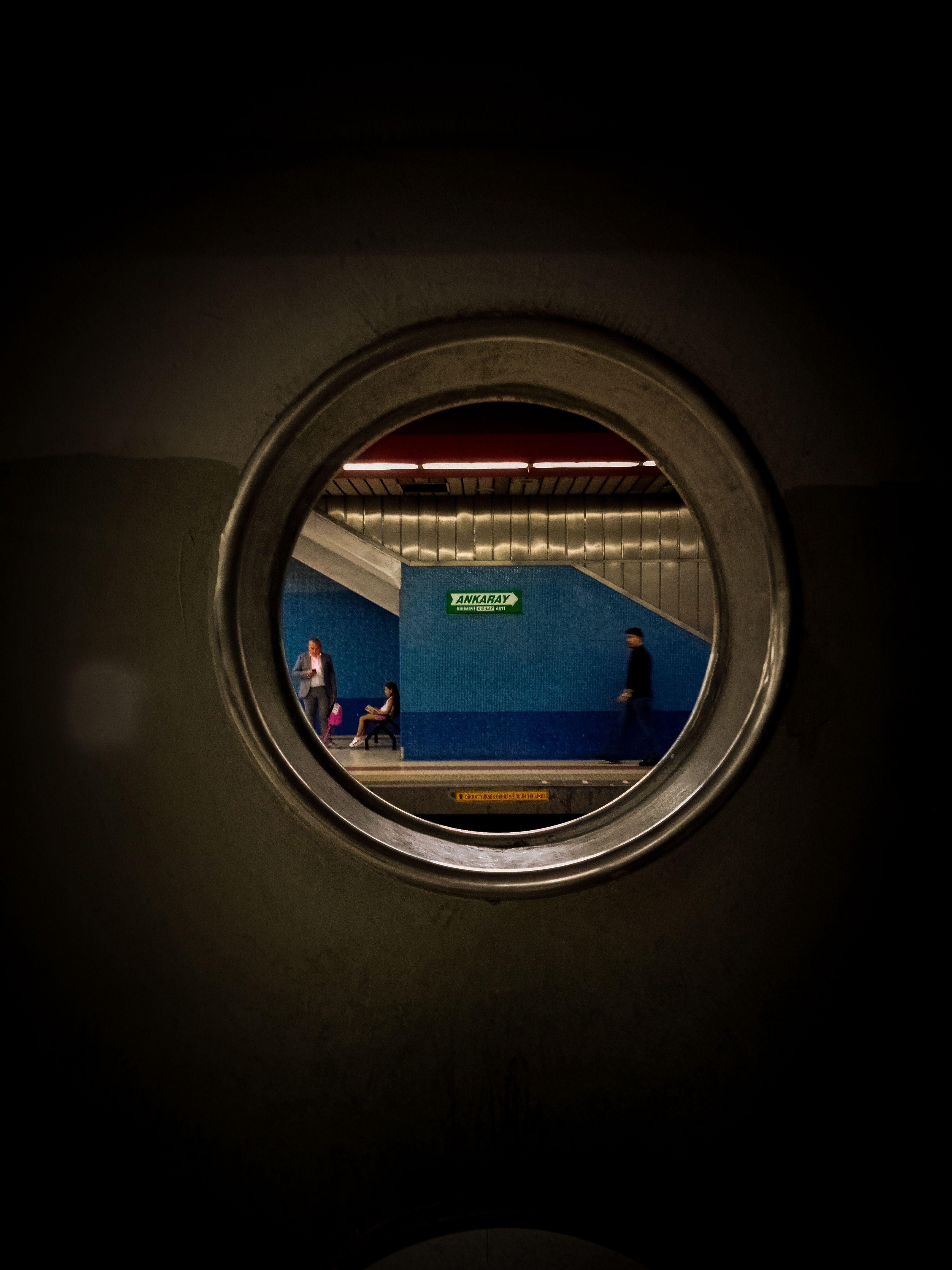 A captivating view of a subway platform through a circular architectural feature.