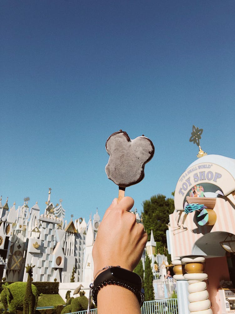 Person Wearing Black Fitness Band Showing Black Popcicle On Stick