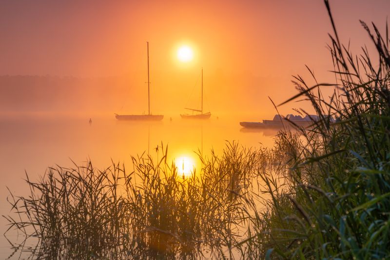 Sunrise over a reservoir with boats