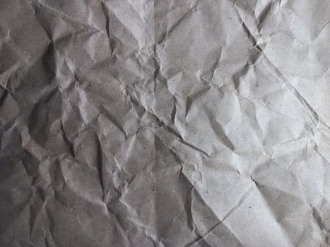 Close-up of a textured crumpled paper surface, showcasing intricate patterns and shadows.