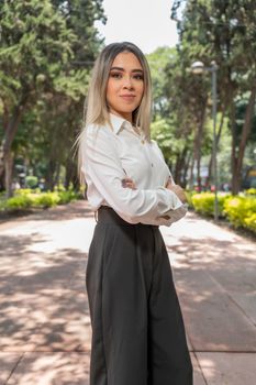 Portrait of a confident woman posing in a park in Ciudad de México with a sunny backdrop.