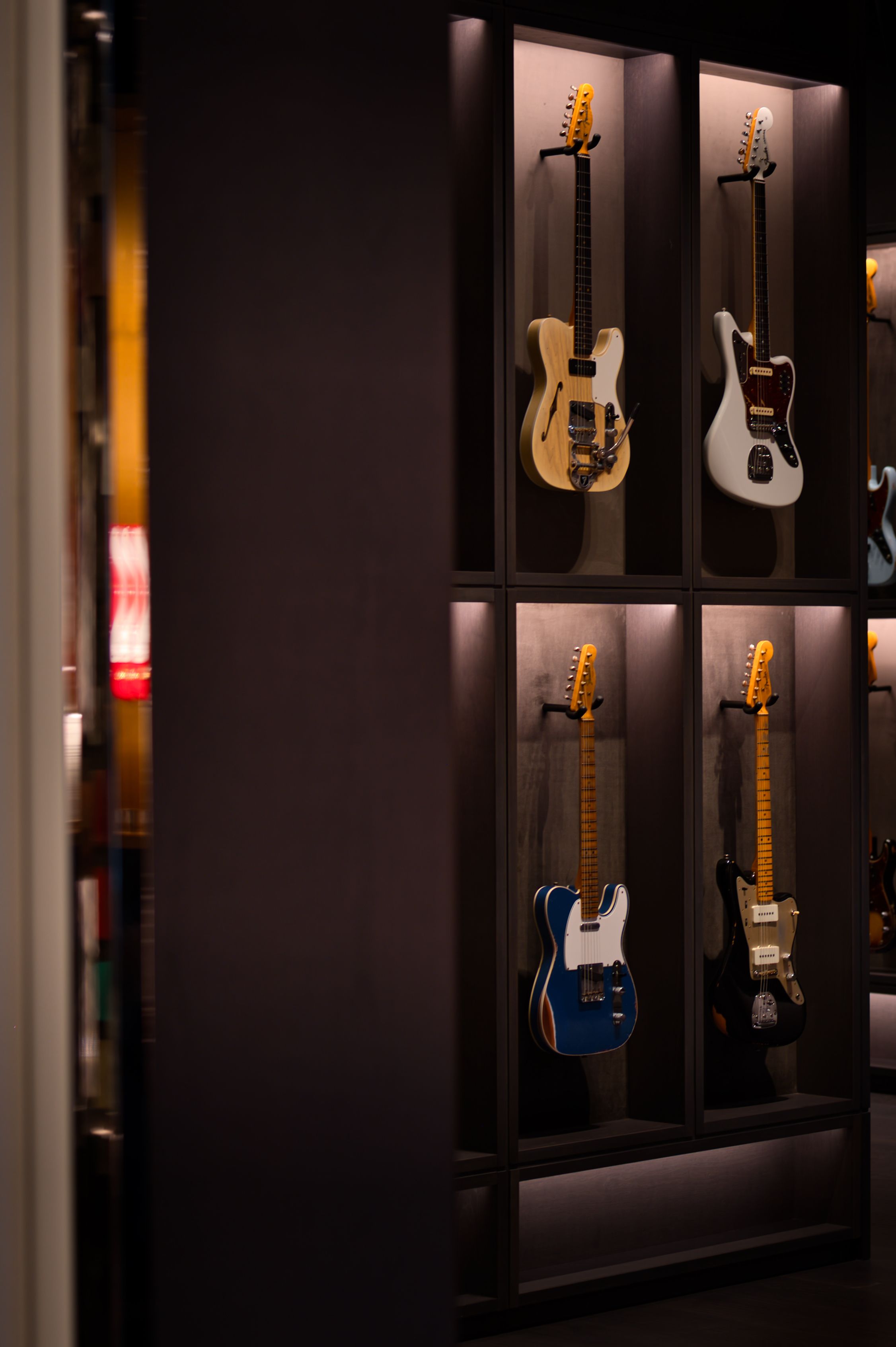 A showcase of various Fender guitars on display at a flagship store in Tokyo, Japan.