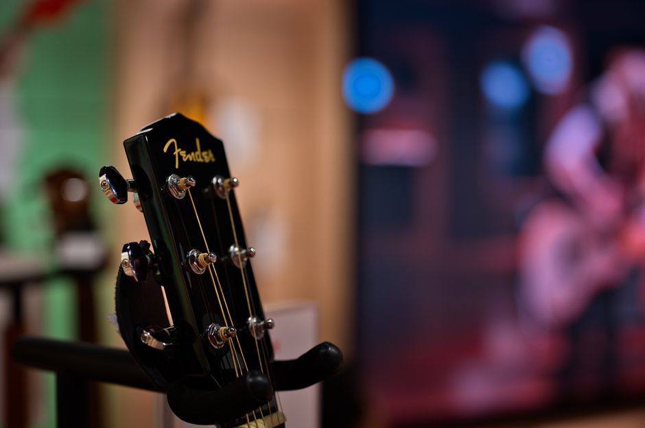 Wzmacniacz gitarowy Fender Deluxe Reverb na małej scenie klubowej lub podczas próby zespołu, podkreślający jego klasyczny design Blackface.