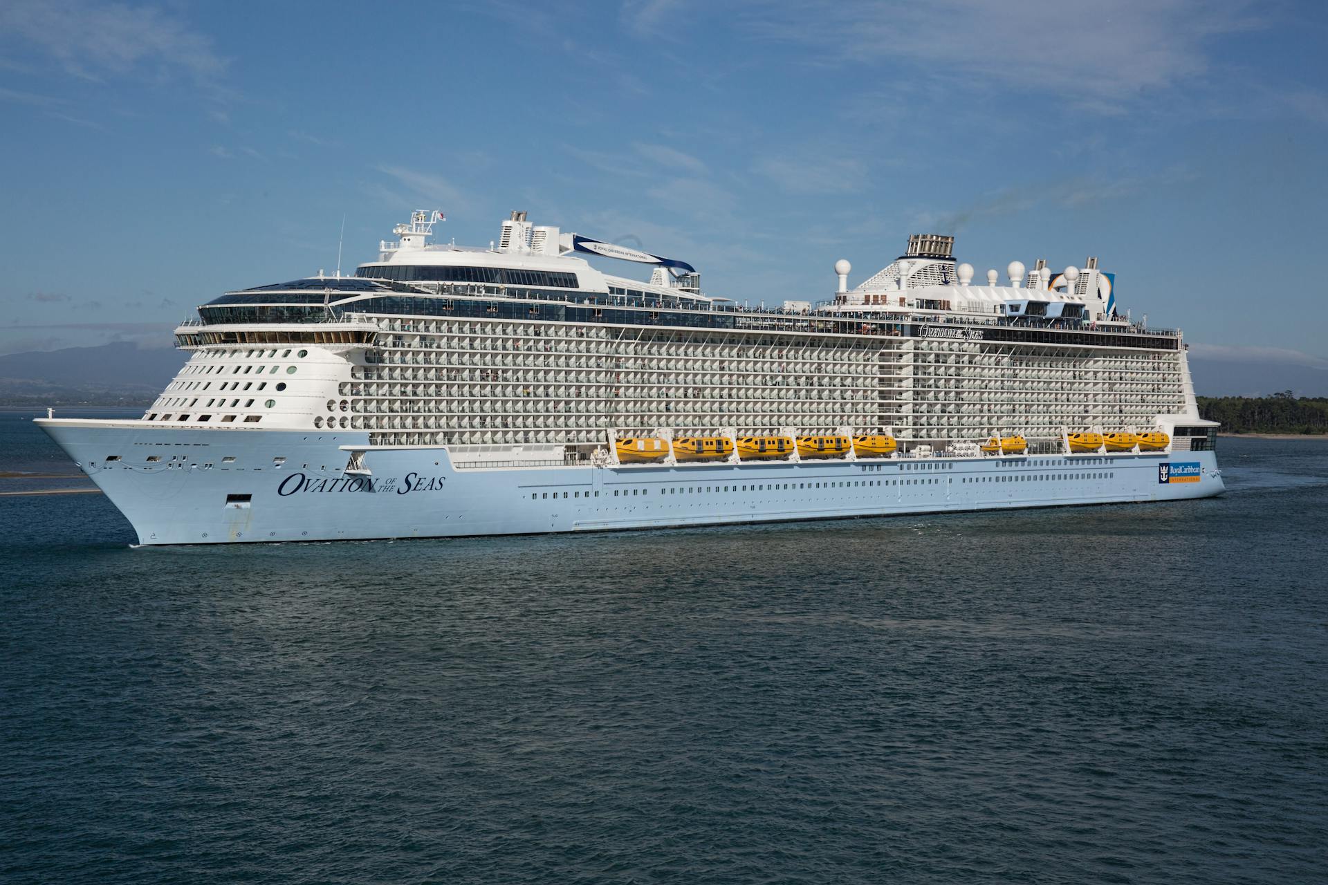 Majestic view of Ovation of the Seas cruise ship sailing on open water, showcasing modern maritime engineering.