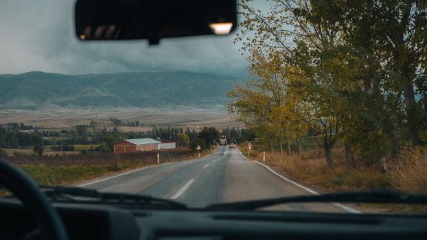 View through car windshield of scenic road in autumn, Merzifon, Türkiye.