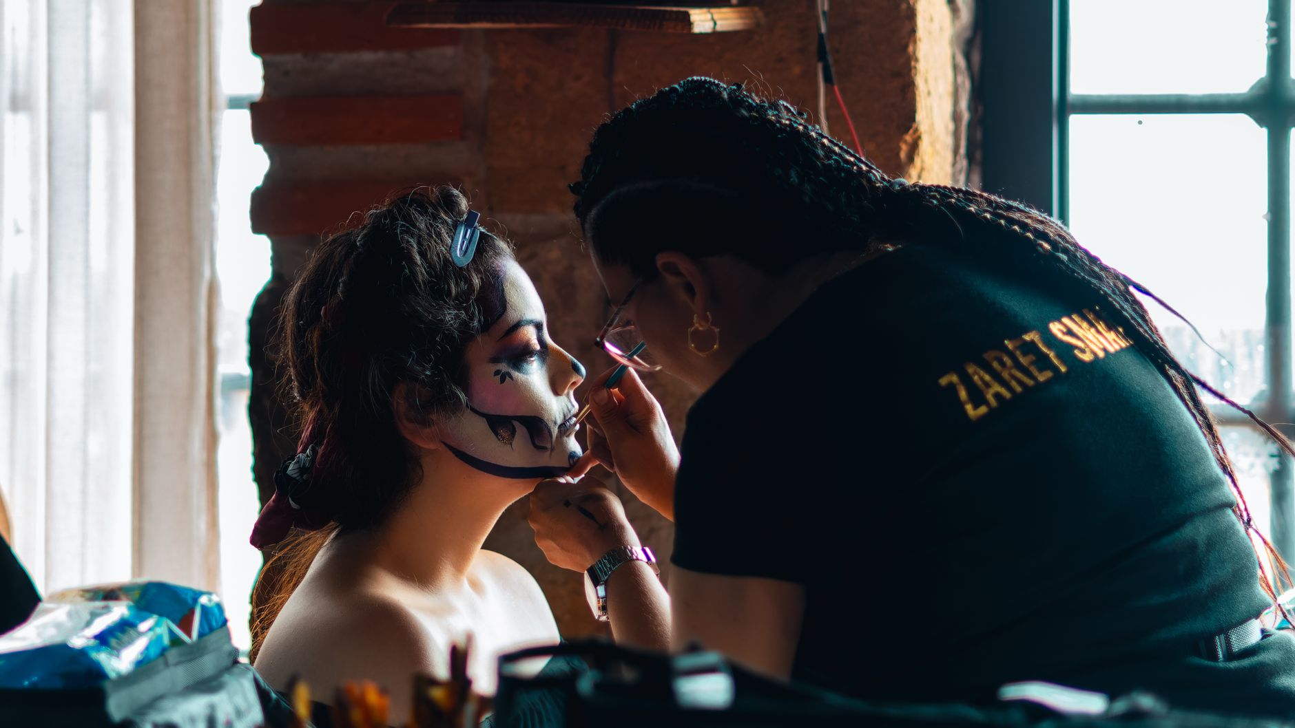 Artist applies detailed makeup for Day of the Dead festivity, highlighting cultural traditions.
