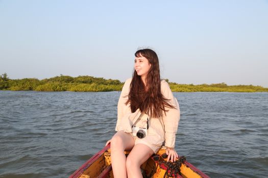 Young woman enjoys a peaceful boat ride in Atins, Maranhão, Brazil during a sunny day.