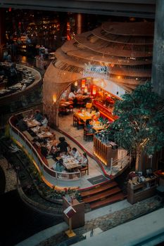 Vibrant indoor dining spot in Bangkok's nightlife with unique architecture and lively atmosphere.