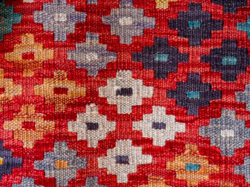 Free Close-up of a vibrant traditional woven rug with geometric patterns and bright colors. Stock Photo