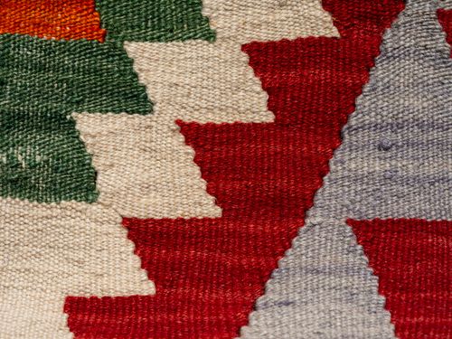 Free Close-up of a colorful woven textile with geometric patterns, rich texture and vibrant colors. Stock Photo