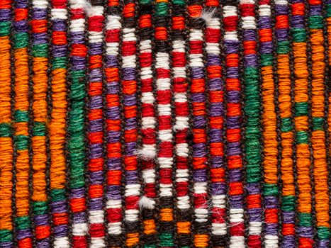 Intricate close-up of a colorful woven textile showcasing vibrant traditional patterns.