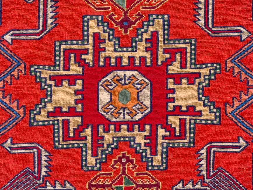 Vibrant close-up of a decorative woven textile with intricate geometric patterns.