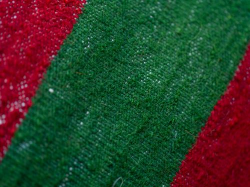 Free Detailed macro shot showcasing the vibrant texture of woven fabric with green and red stripes. Stock Photo