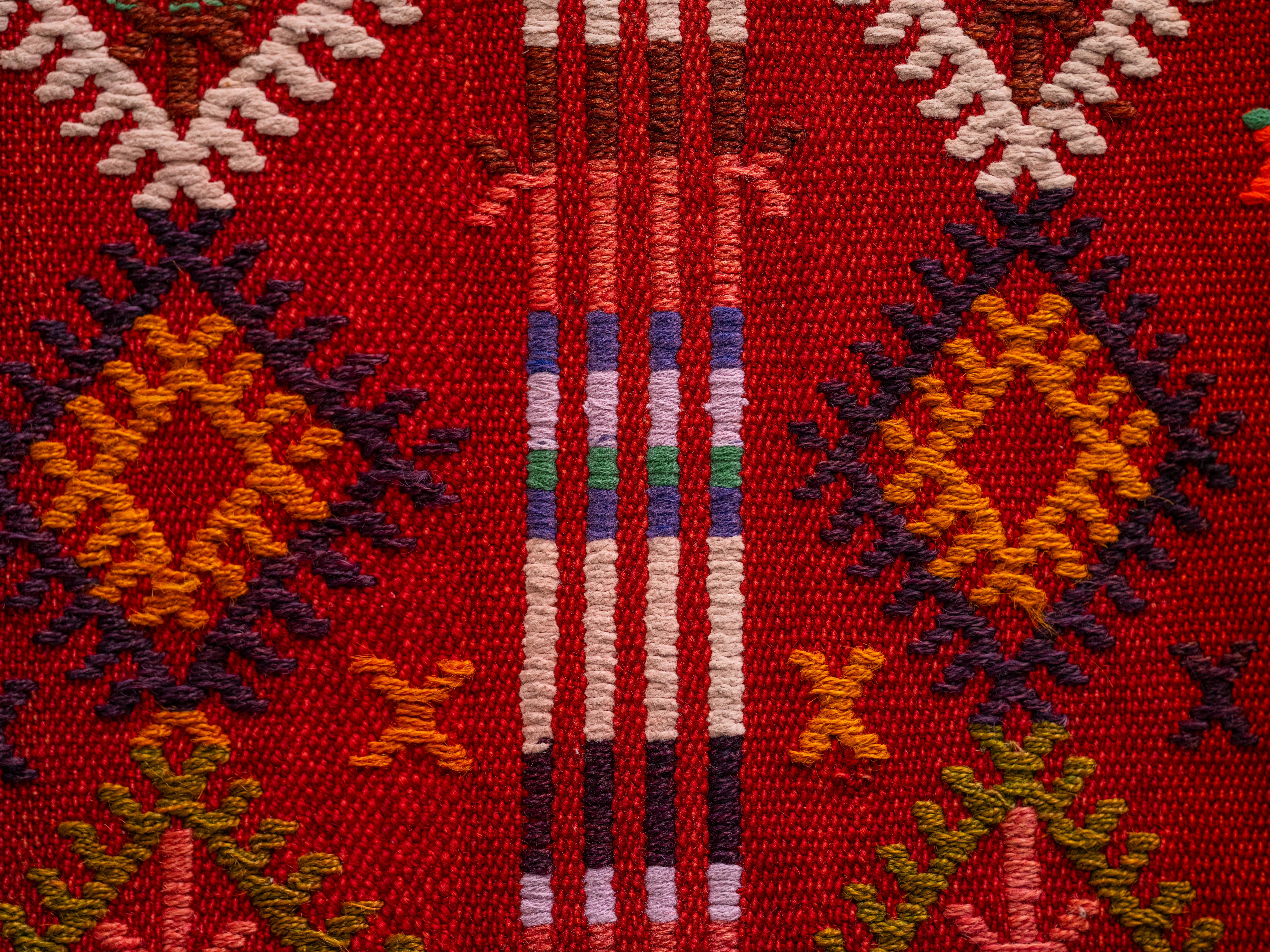 Close-up of a colorful and traditional Turkish Kilim textile pattern showcasing intricate woven designs.