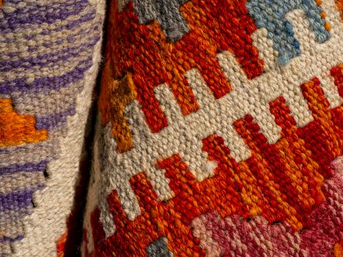Free Close-up of a vibrant traditional woven textile with intricate patterns and rich colors. Stock Photo