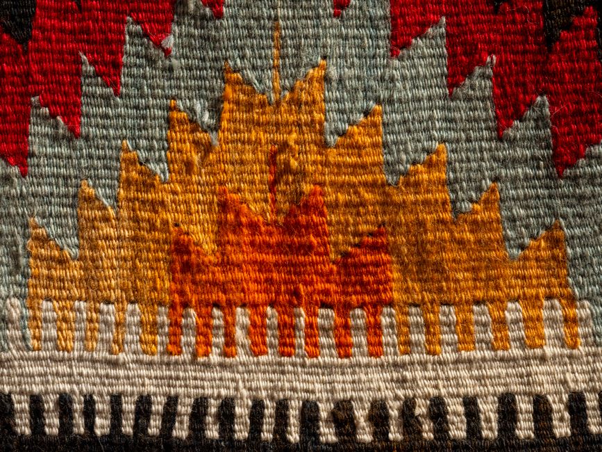 Close-up of a colorful woven textile featuring triangular geometric designs.