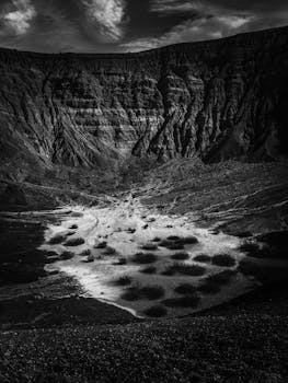 黑白影像下的沙漠峡谷与悬崖，展现出崎岖地形的戏剧性自然风光
