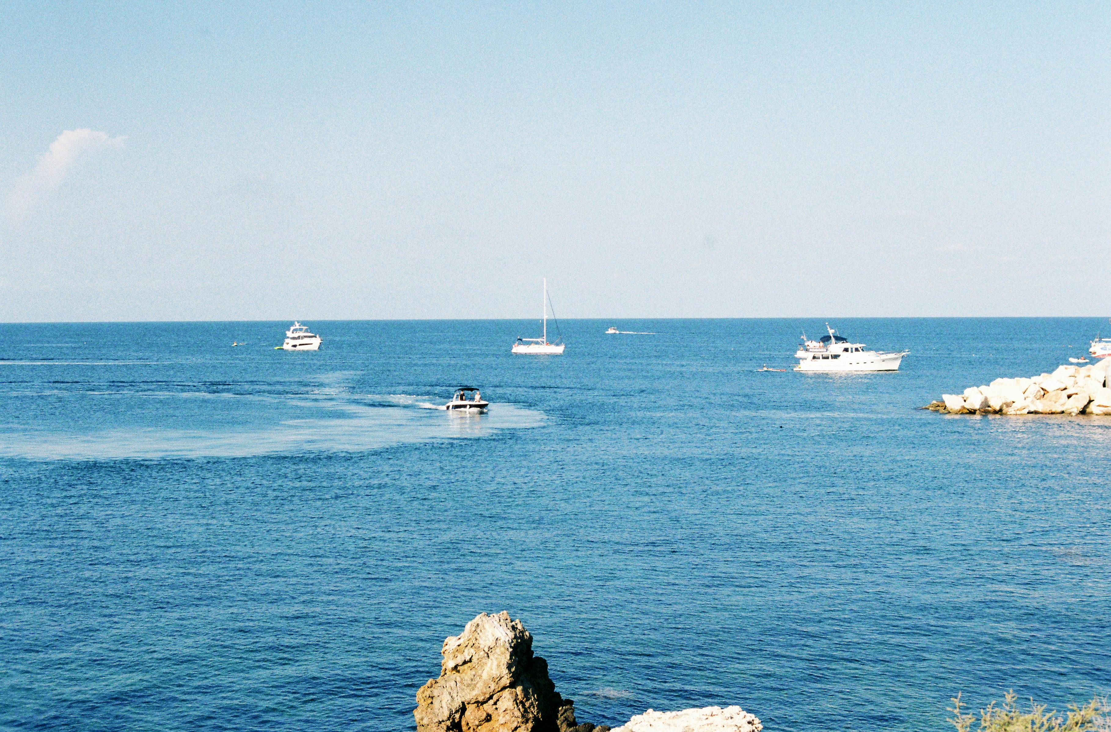 a boat is sailing in the ocean near rocks