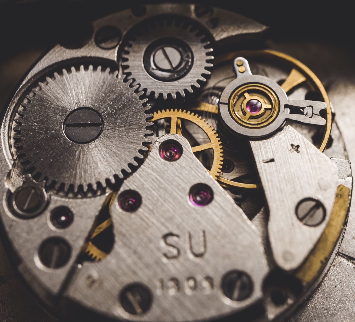 Film still — macro of a hand-wound watch movement, wheels and jewels. Photo by Олександр К on Pexels