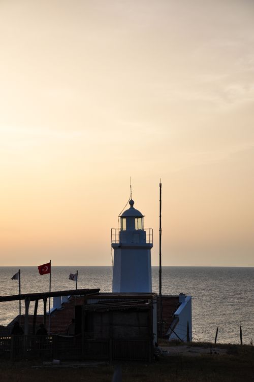Free Lighthouse on the coast with ocean view at sunset, creating a serene seascape. Stock Photo
