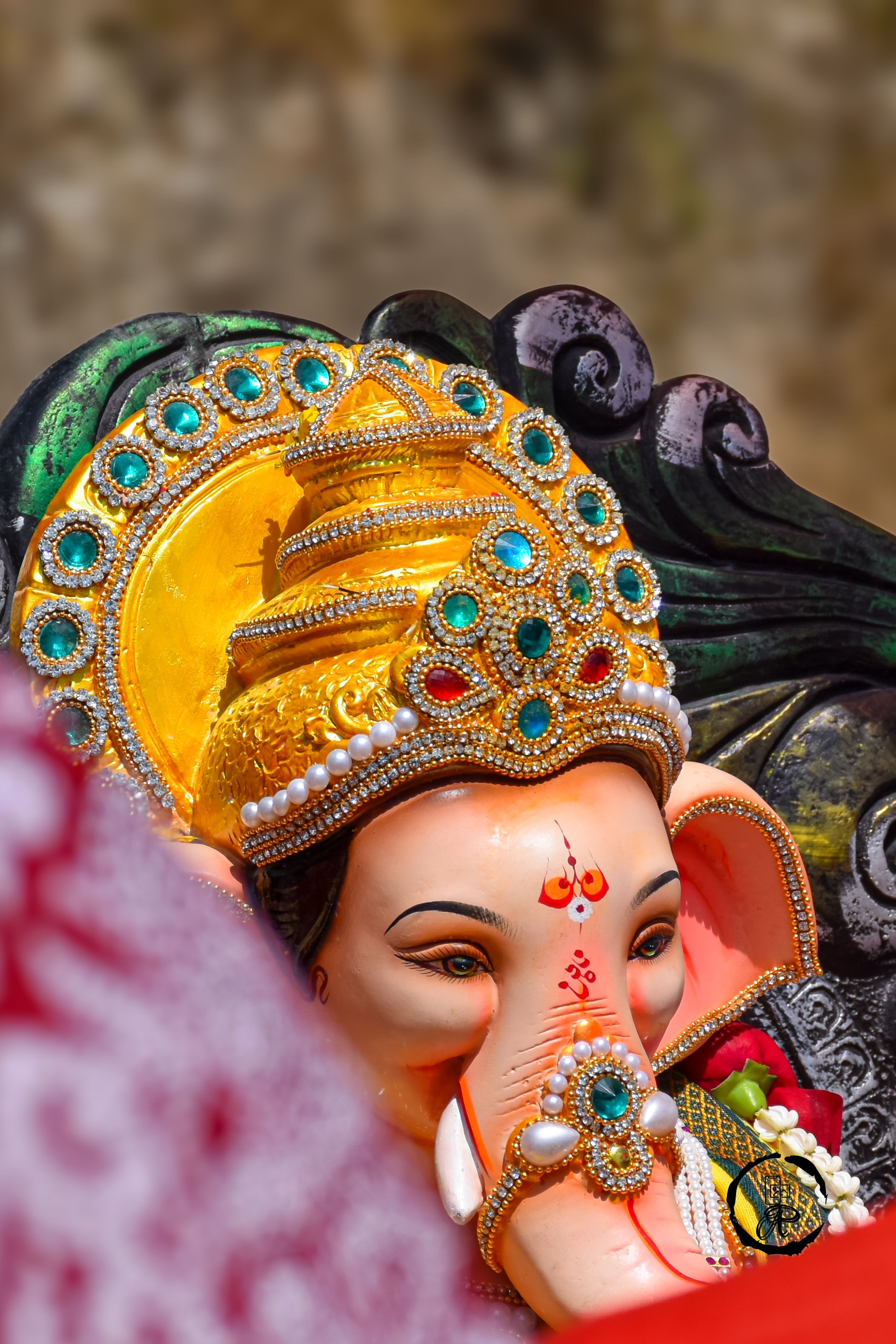 Vibrant Ganesh idol adorned with jeweled crown, perfect for celebrating Ganesh Chaturthi.