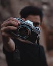 一个人拿着经典的美能达相机，突出了其镜头和复古设计