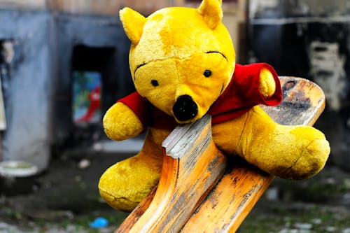 Free Winnie the Pooh Plush Toy on Seesaw Stock Photo