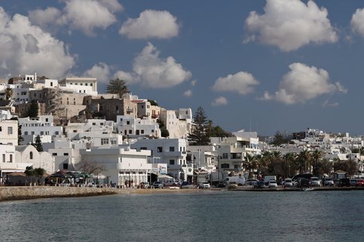 Explore the charming architecture of Naxos, Greece, framed by a bright blue sky and sparkling sea.