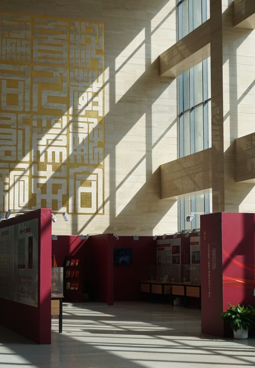 Free Sunlit interior of a modern architectural building with intricate wall patterns. Stock Photo