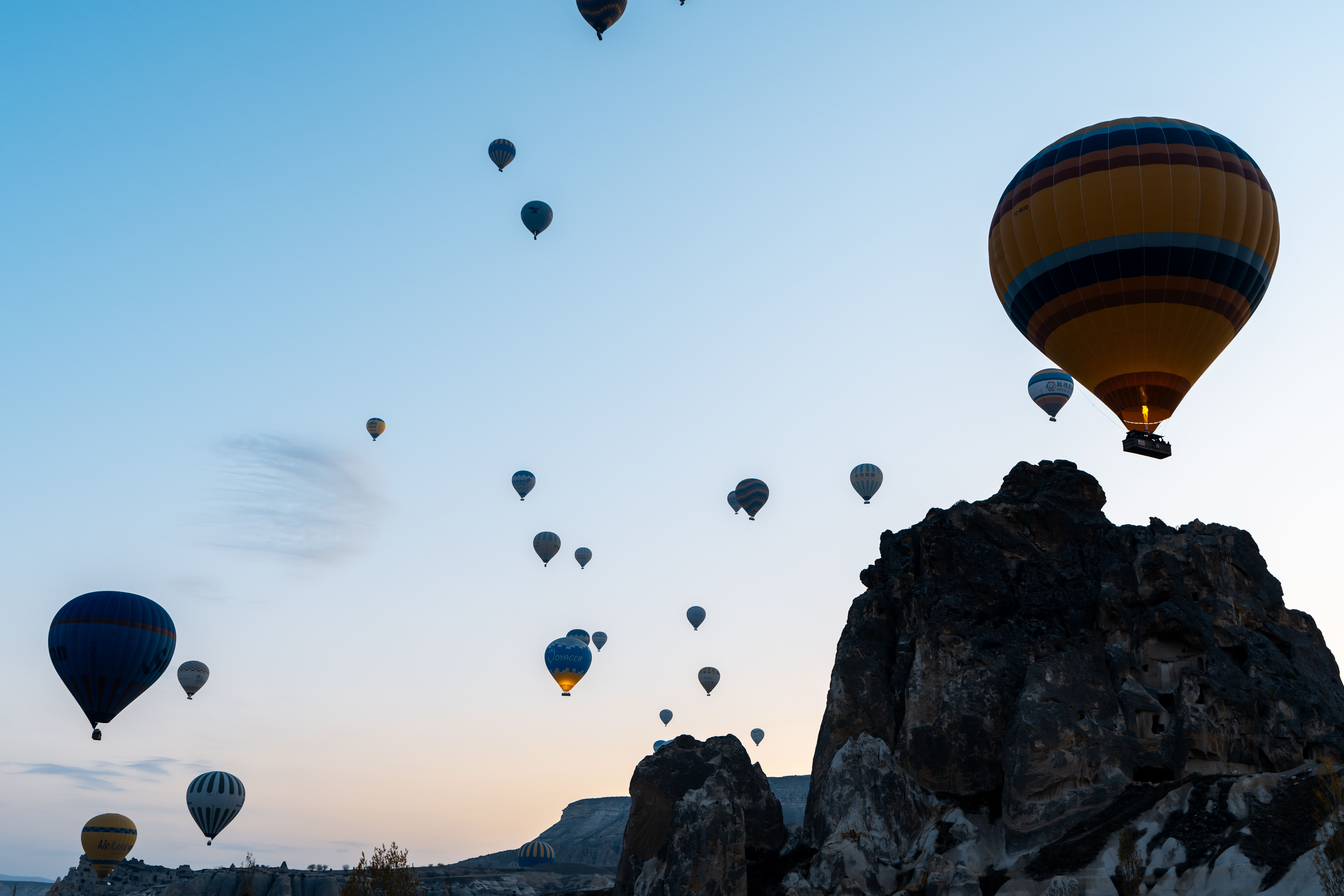 Hot air balloons floating over a rocky landscape at dusk, capturing the serene beauty of a twilight adventure.