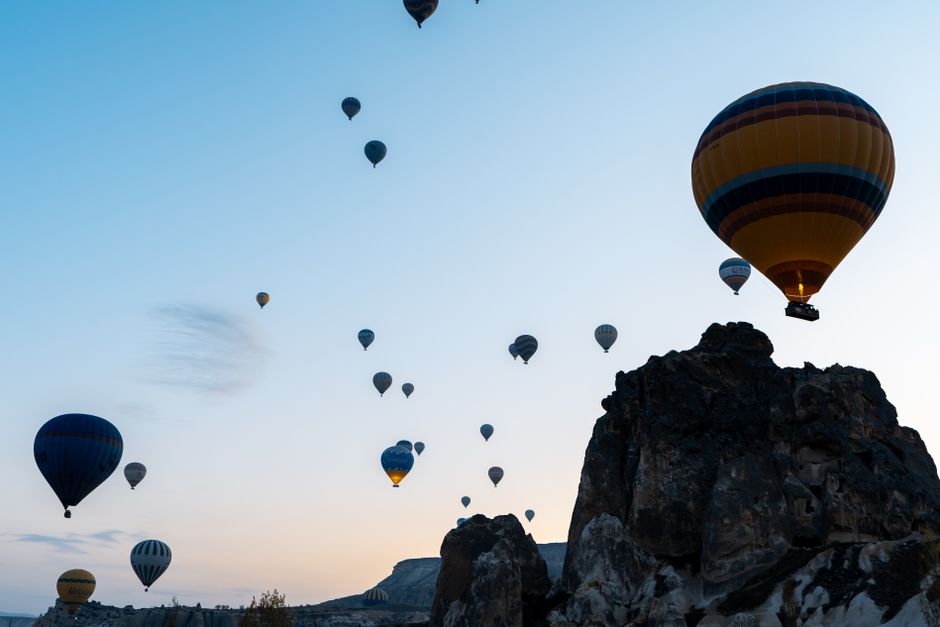 Hot air balloons floating over a rocky landscape at dusk, capturing the serene beauty of a twilight adventure.