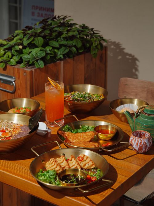 Free Variety of Asian dishes with drinks on a sunny outdoor table setting. Stock Photo