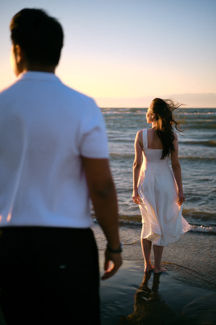 Couple strolling by the ocean during a serene sunset, capturing a romantic moment.