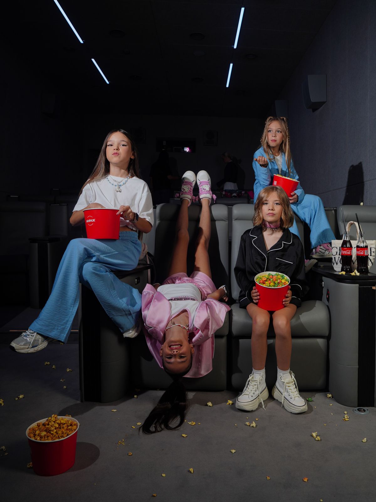 Kids enjoying a movie night at a cinema with popcorn.