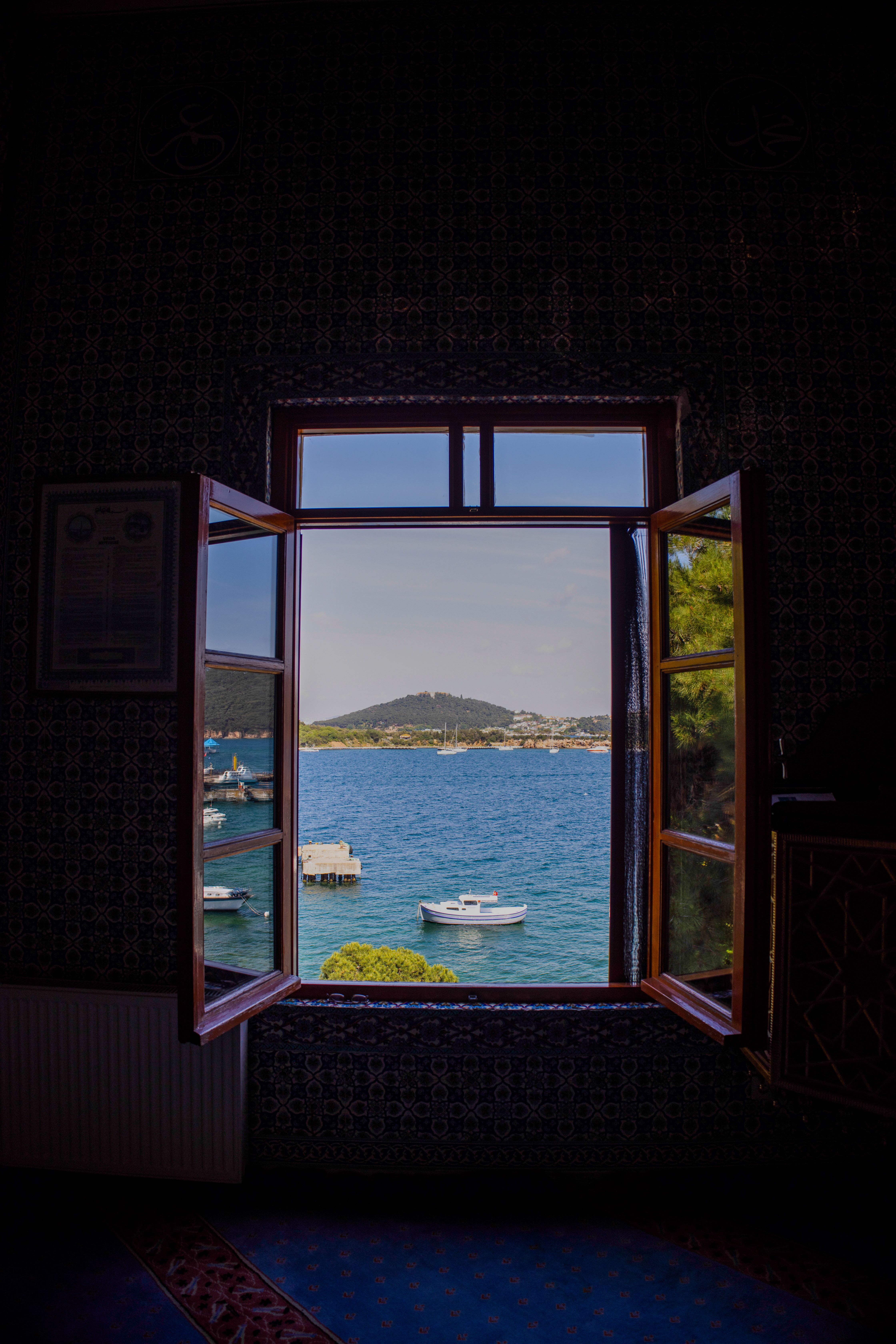 Free A tranquil ocean view through an open window, perfect for travel and relaxation themes. Stock Photo