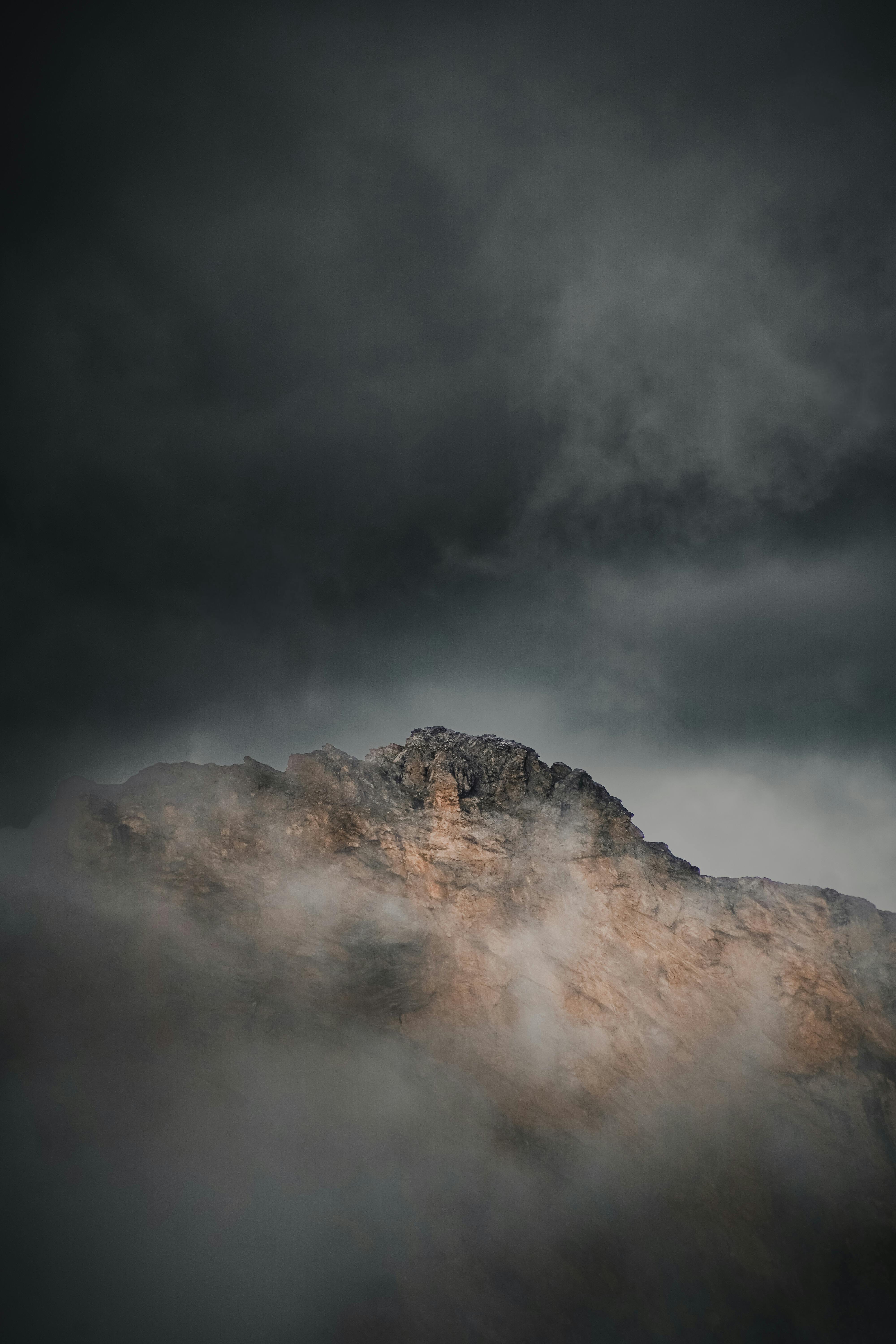 A dramatic view of a fog-covered mountain peak in Tyrol, Austria, capturing the rugged natural beauty.
