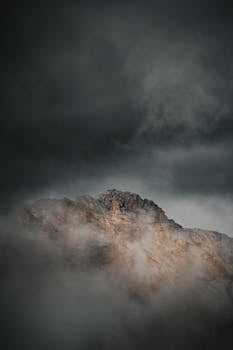 A dramatic view of a fog-covered mountain peak in Tyrol, Austria, capturing the rugged natural beauty.