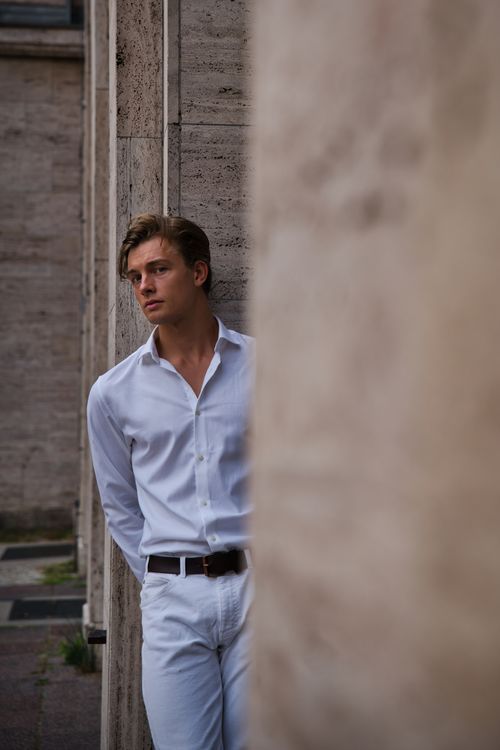 Free Young male model posing in a stylish white outfit during an outdoor photoshoot in Berlin. Stock Photo