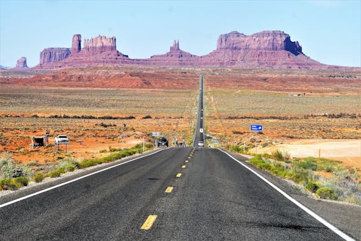 Iconic highway leading to red rock formations in Monument Valley, Utah.