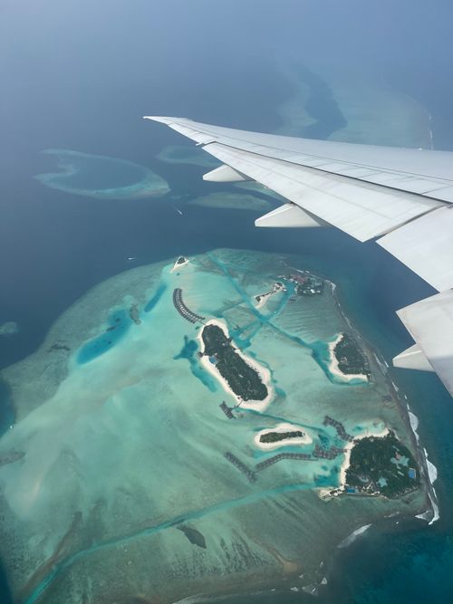 Free Stunning aerial view of the Maldives' blue waters and islands as seen from an airplane window. Stock Photo
