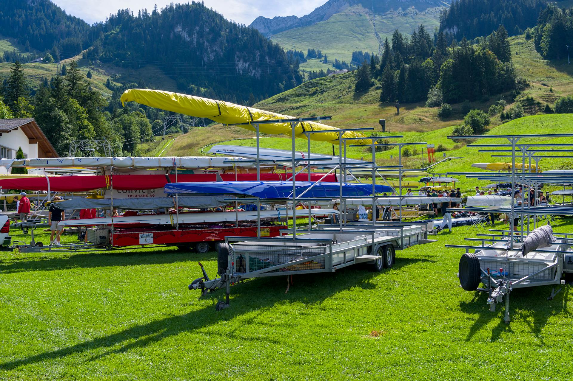 Rowing boat trailers in a picturesque Swiss mountain setting, showcasing summer's vibrant greenery.