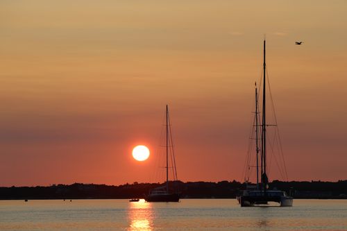 Free Serene sunrise in Nantucket with sailboats silhouetted against a vibrant sky. Stock Photo