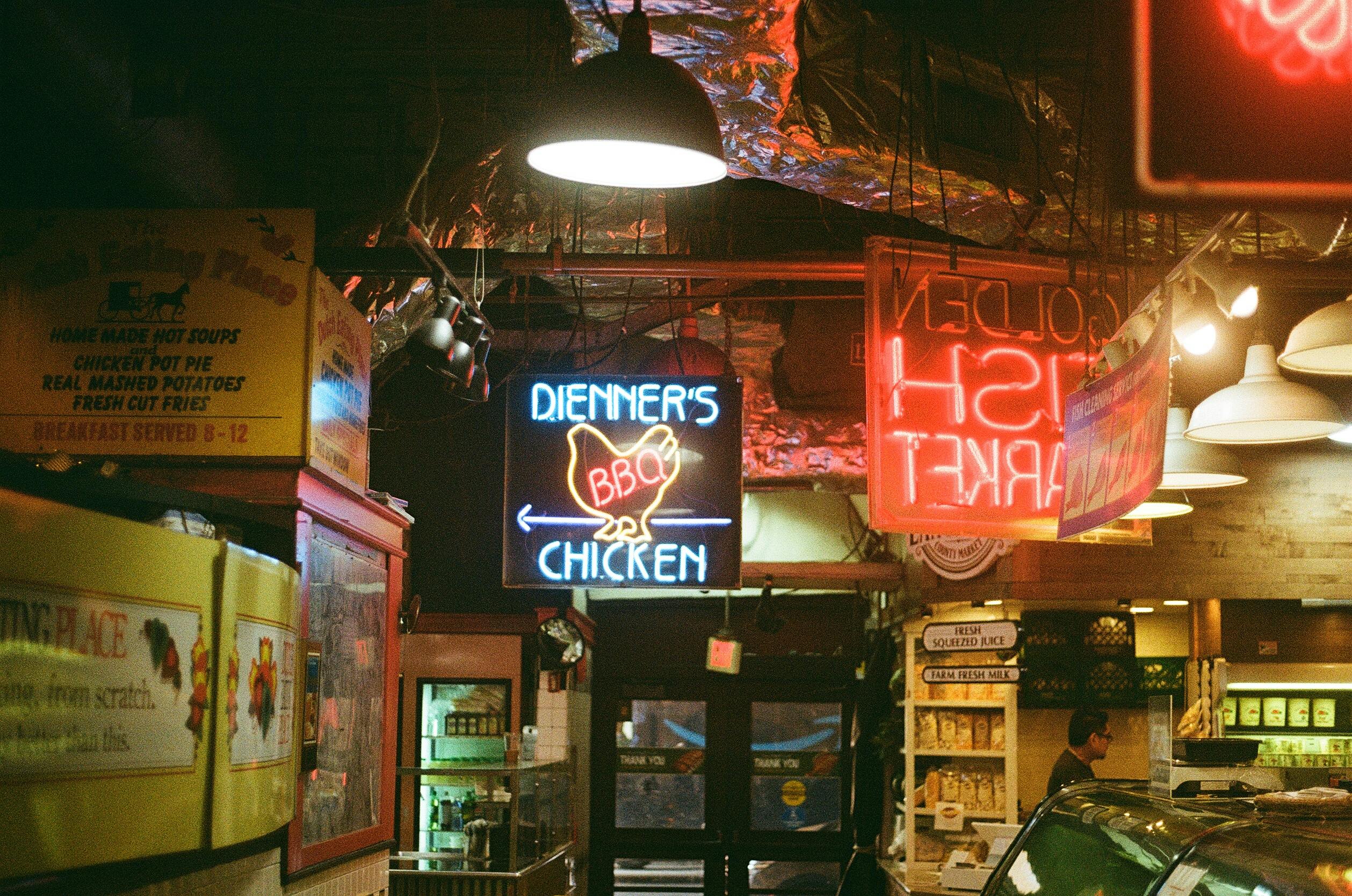 Gratis Vivaci insegne al neon illuminano un vivace mercato di Filadelfia, dove vengono presentati i piatti della cucina locale. Foto a disposizione