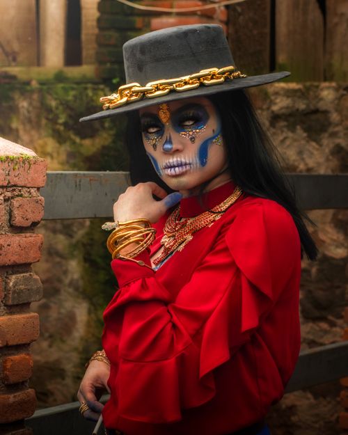 Free Striking portrait of a model in traditional Día de los Muertos attire with elaborate face paint. Stock Photo