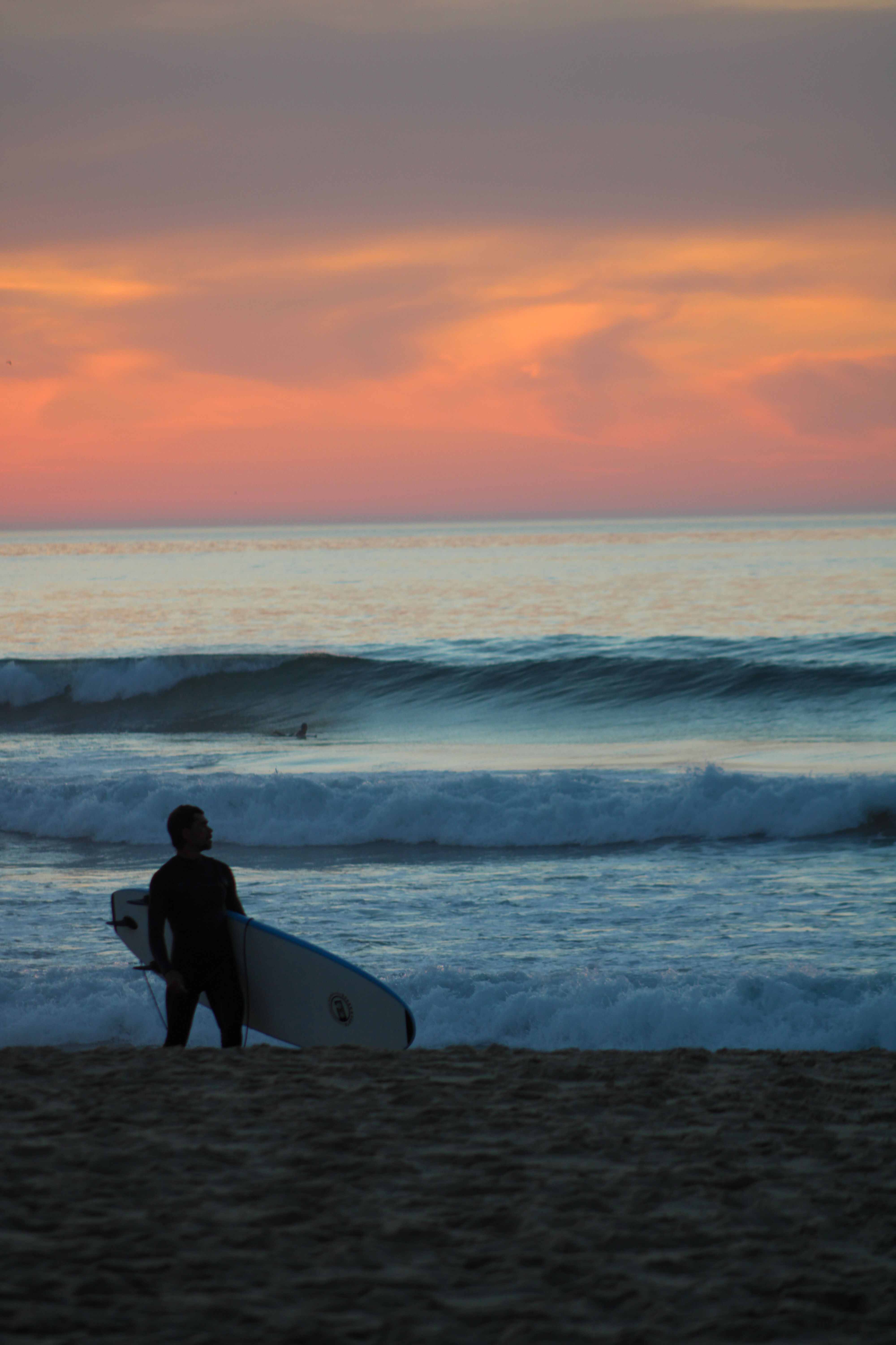 Surfer at the shoreline in Ericeira, Portugal