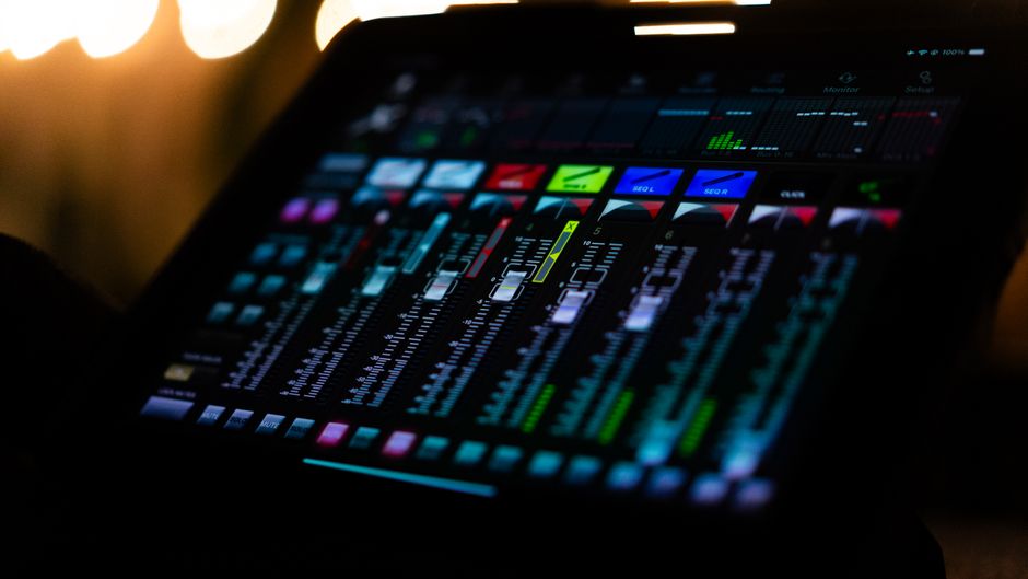 A vibrant and colorful digital audio mixer interface captured under studio lighting, showcasing detailed controls.