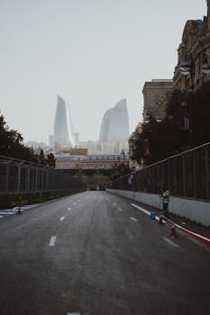 Wide road in Baku with visible Flame Towers and modern architecture.